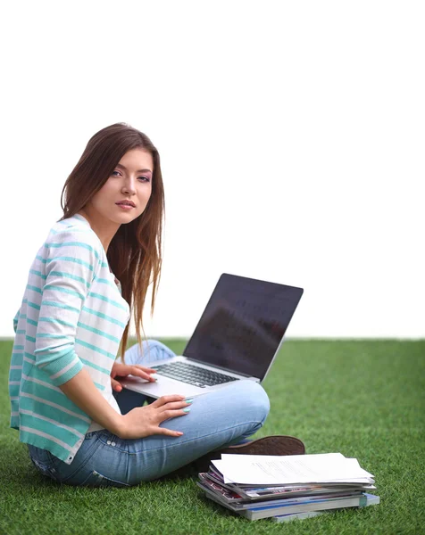 Jeune femme avec ordinateur portable assis sur l'herbe verte — Photo