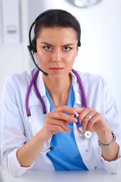 Doctor wearing headset sitting behind a desk with laptop — Stock Photo, Image