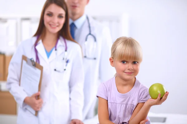 Child and medicine concept - female doctor giving an apple to little girl — Stock Photo, Image