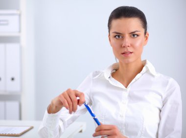 Ofiste dizüstü bilgisayarı olan çekici bir iş kadını.