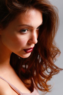 Gri arka planda izole edilmiş güzel bir kadının portresi.