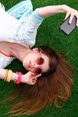 güzel ve genç birbayan yeşil çim yalan onu telefonla selfie yapma