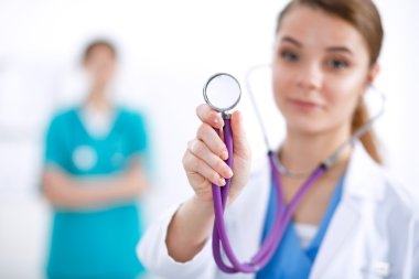 Steteskoplu kadın doktor dinliyor.