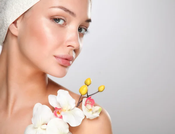 Woman in towel with orchid flowers — Stock Photo, Image