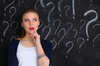 soru işareti gri bir arka plan üzerinde bulunan genç kız