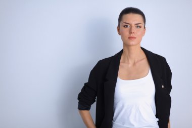 ayakta, gri arka plan üzerinde izole genç kadın