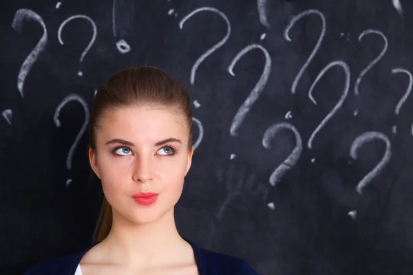 Young girl with question mark on a gray background — Stock Photo, Image