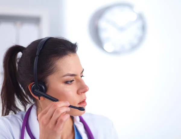 Doctor wearing headset sitting behind a desk with laptop — Stock Photo, Image