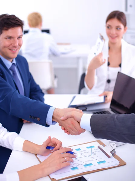 Empresários apertando as mãos, terminando uma reunião, no escritório — Fotografia de Stock
