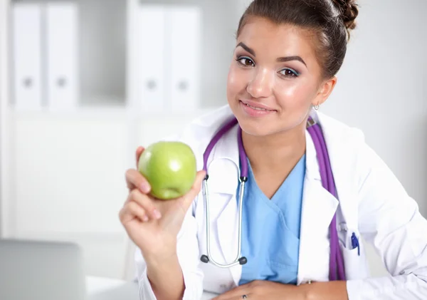 Female doctor hand holding a green apple, standing — Stock Photo, Image