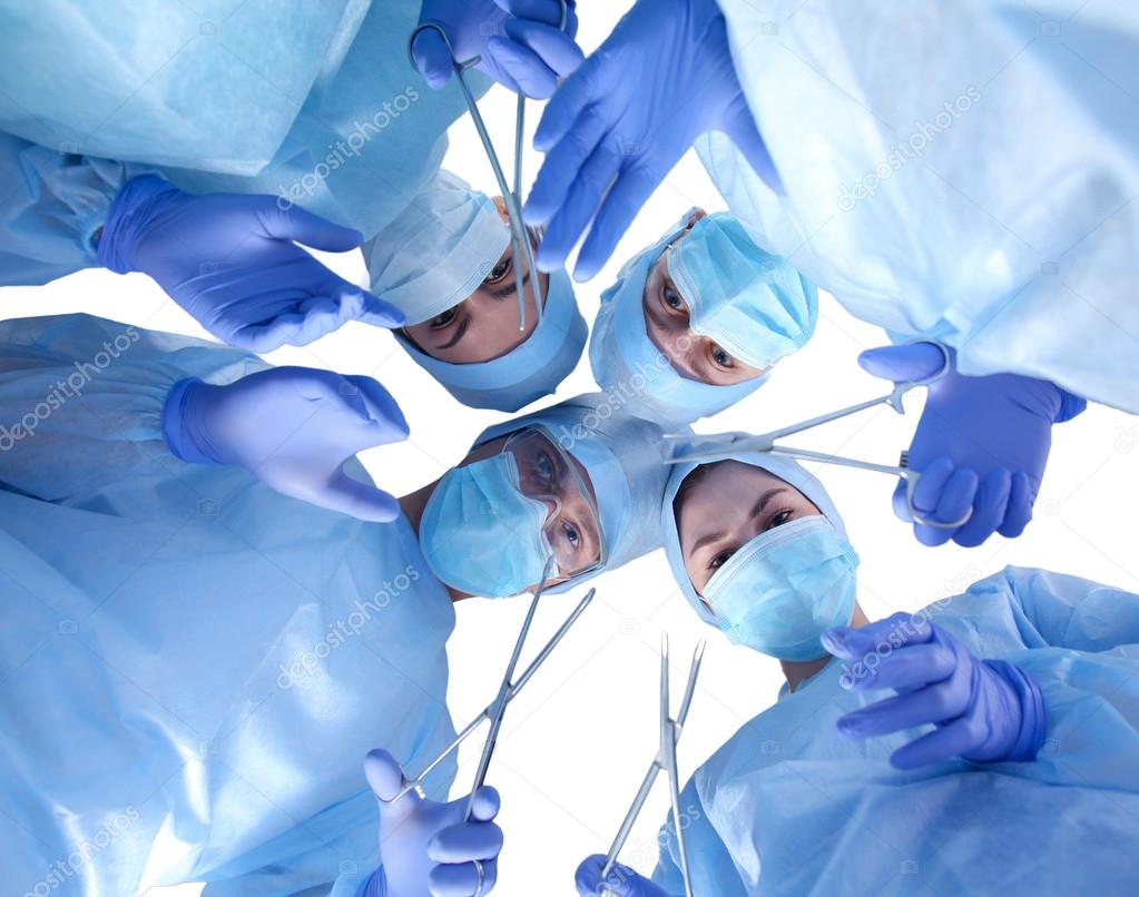 Surgeons holding medical instruments in hands and looking at patient