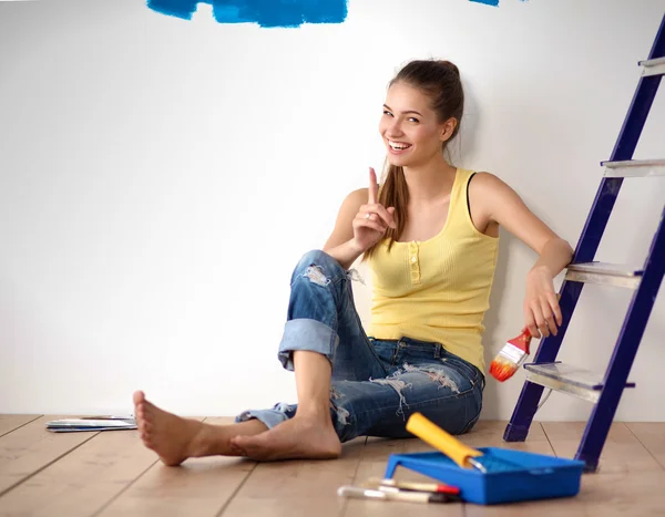 Portrait de peintre femme assise sur le sol près du mur après la peinture . — Photo