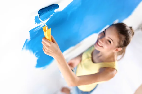 Beautiful young woman doing wall painting — Stock Photo, Image