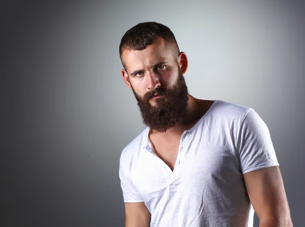 Retrato de homem barbudo bonito em pé, isolado sobre fundo cinza — Fotografia de Stock