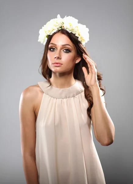 Retrato de uma mulher bonita com flores no cabelo. Moda — Fotografia de Stock