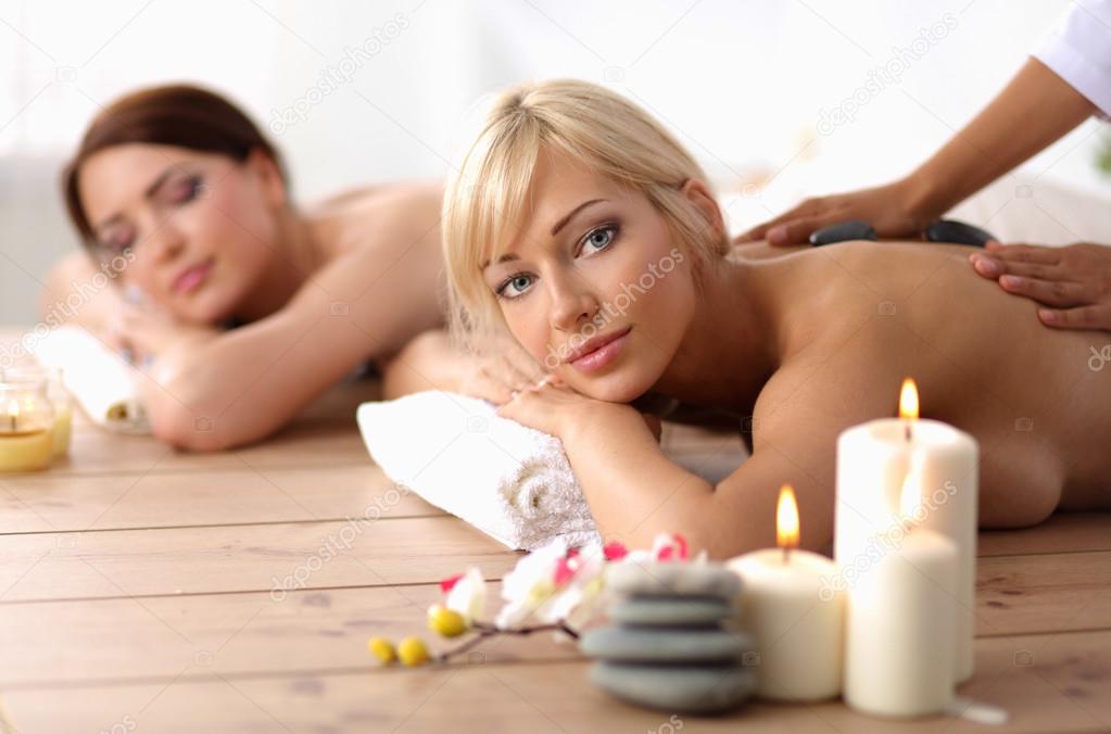 Two young beautiful women relaxing and enjoying at the spa center