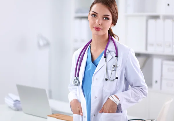 Portrait of young woman doctor with white coat standing in hospital — Stock Photo, Image