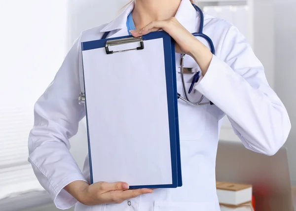 Улыбающаяся женщина-врач с папкой в форме стоя — стоковое фото