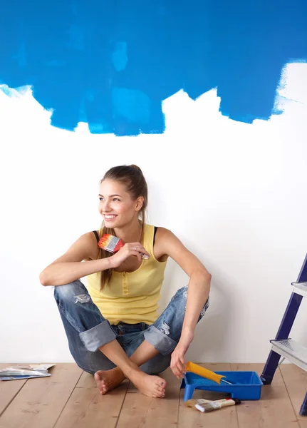 Retrato de pintora sentada en el suelo cerca de la pared después de pintar . —  Fotos de Stock