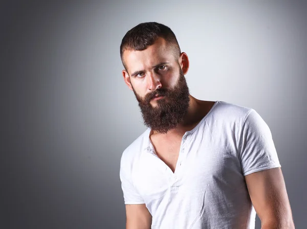 Retrato de homem barbudo bonito em pé, isolado sobre fundo cinza — Fotografia de Stock