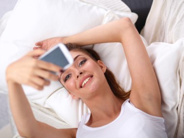 Yatak odasında cep telefonu ile kendini bir fotoğraf çekici mutlu esmer