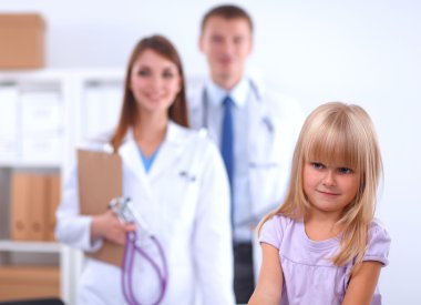 Kadın doktor ameliyatta steteskopla çocuğu muayene ediyor.