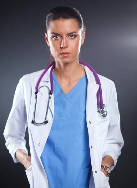Mladá lékařka se stetoskopem izolované na šedé — Stock fotografie