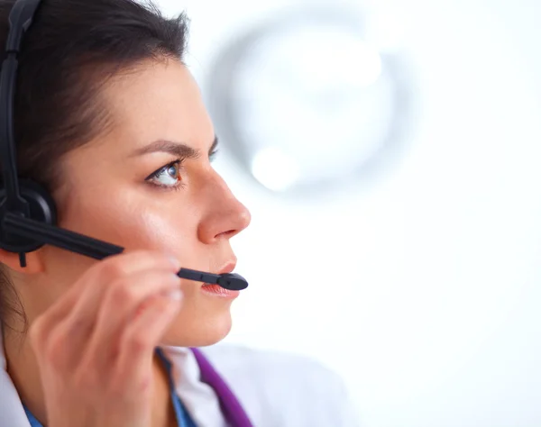 Médico con auriculares sentado detrás de un escritorio con portátil —  Fotos de Stock