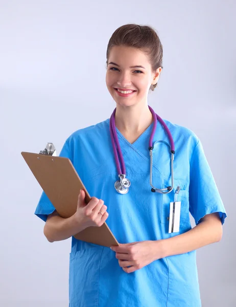 Médico sonriente con una carpeta en uniforme de pie en el hospital — Foto de Stock