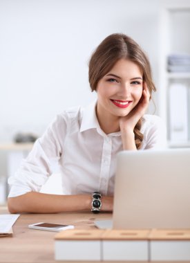 Ofiste masa başında oturan çekici bir iş kadını.