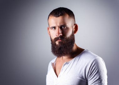 ayakta, gri arka plan üzerinde izole yakışıklı sakallı adam portresi