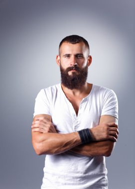 ayakta, gri arka plan üzerinde izole yakışıklı sakallı adam portresi