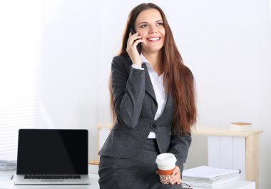 Ofiste gülümseyen iş kadını konuşuyor.