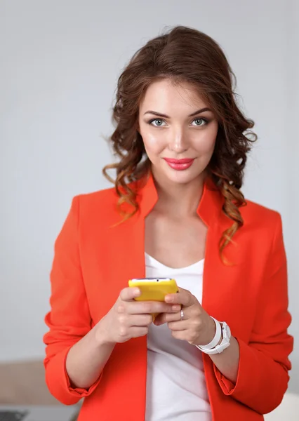 Schöne Geschäftsfrau mit Handy im Büro — Stockfoto