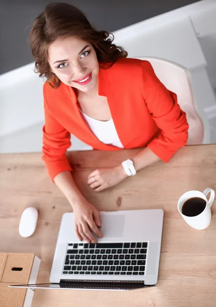 Mujer atractiva sentada en el escritorio en la oficina, trabajando con el ordenador portátil — Foto de Stock
