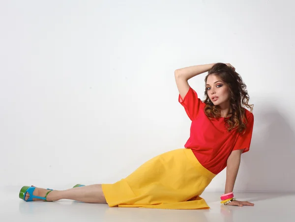 Young woman sitting on the floor, isolated in white background — Stock Photo, Image