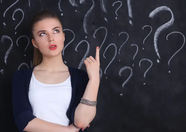 Young girl with question mark on a gray background — Stock Photo, Image