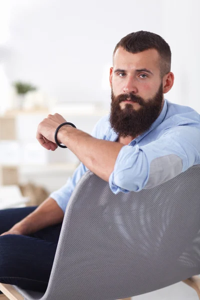 Young businessman sitting on chair in office — Stock Photo, Image