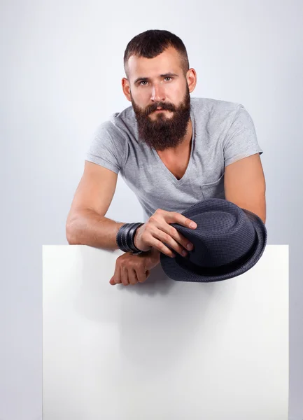 Retrato de un joven con sombrero de pie cerca del blanco, aislado sobre fondo blanco —  Fotos de Stock