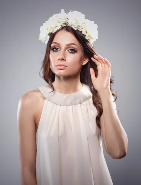 Retrato de uma mulher bonita com flores no cabelo. Moda — Fotografia de Stock