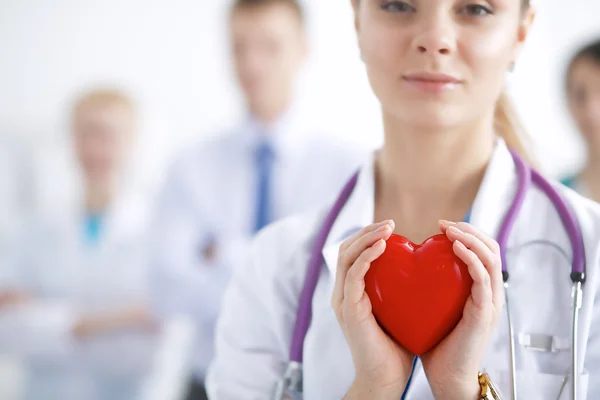 Female doctor with stethoscope holding heart — Stock Photo, Image