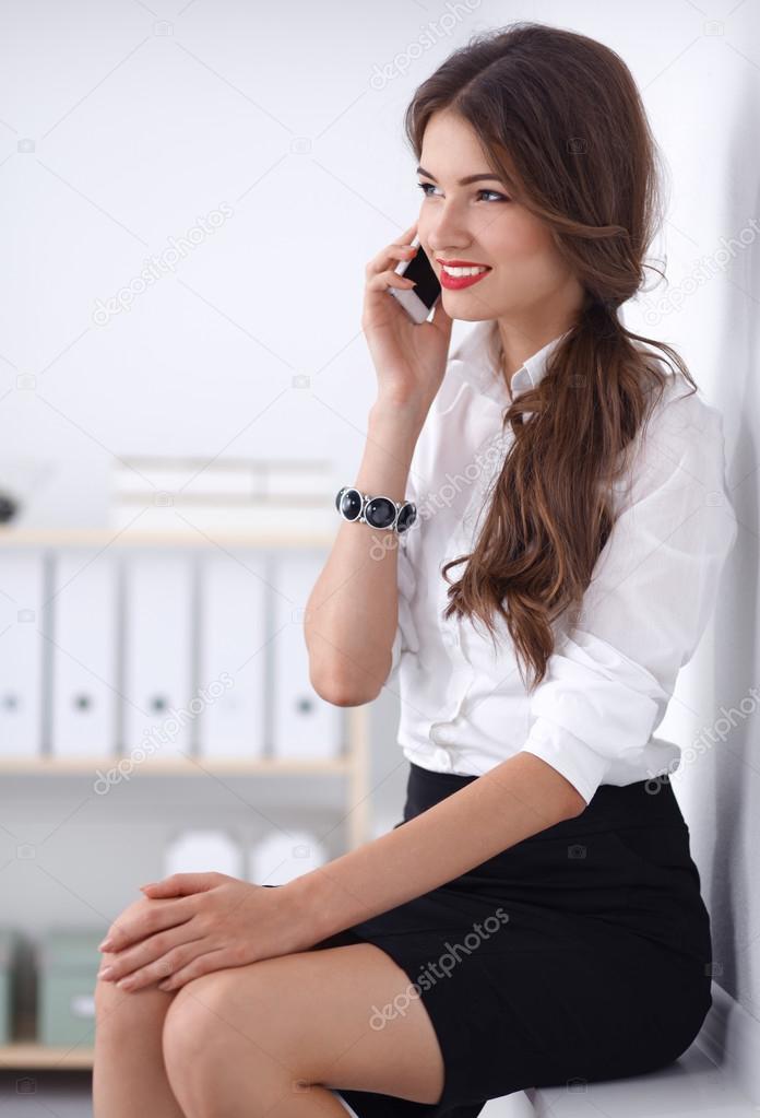 Smiling businesswoman talking on the phone at the office