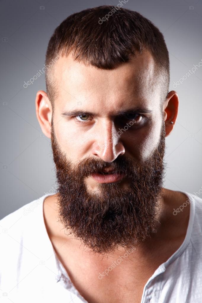 Portrait of handsome bearded man standing, isolated on grey background