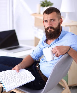 sandalye ile office kitapta oturan genç işadamı