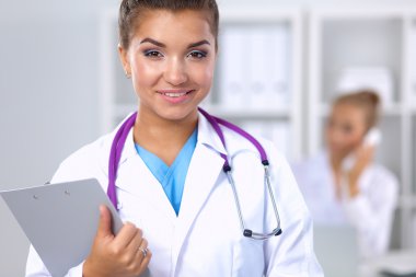 Hastanede üniformalı, gülümseyen bir kadın doktor.