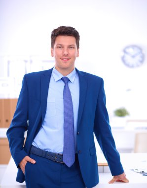 Ofiste masasının karşısında duran bir iş adamı ya da yönetici. 