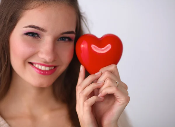 Retrato de bela mulher feliz segurando um coração símbolo . — Fotografia de Stock