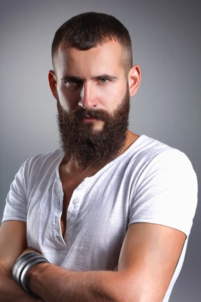 Retrato de homem barbudo bonito em pé, isolado sobre fundo cinza — Fotografia de Stock