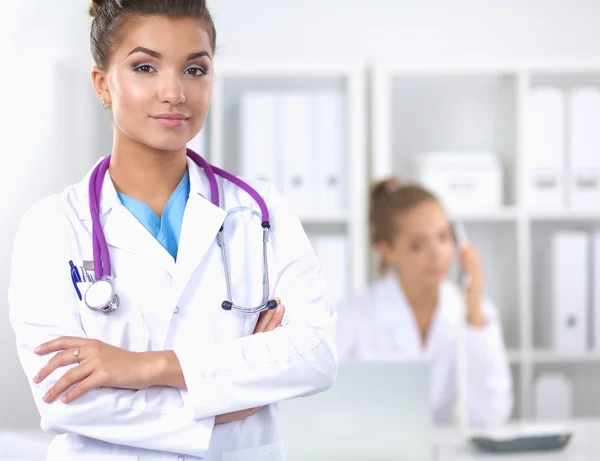 Portrait of young woman doctor with white coat standing in hospital — Stock Photo, Image