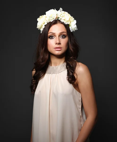 Retrato de una hermosa mujer con flores en el pelo. Moda — Foto de Stock